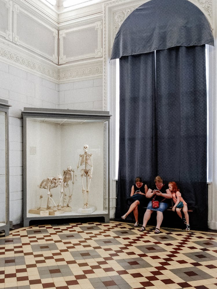 Family Sitting On A Bench In A Museum