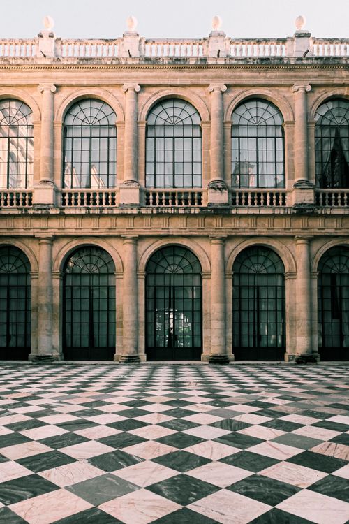 Free A classic architectural facade with arched windows and a distinctive checkered floor pattern. Stock Photo