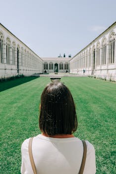 阳光明媚的修道院庭院里，草坪翠绿，一名妇女的背影映入眼帘