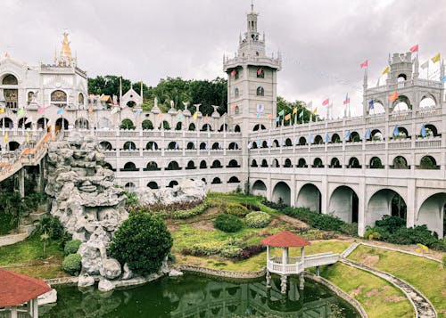 Ancient catholic Monastery of the Holy Eucharist with arched details located in well groomed park with pond in Cebu