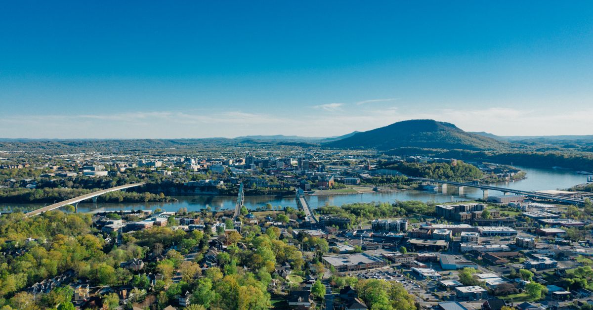 A stunning aerial view of Chattanooga, TN with the Tennessee River and scenic mountains.
