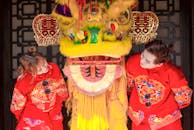 在传统节日庆典上，两名身着色彩缤纷服装的表演者带来了充满活力的舞狮场景