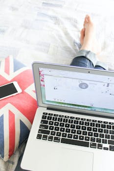 Relaxing work setup on bed with laptop and smartphone, perfect for remote work.