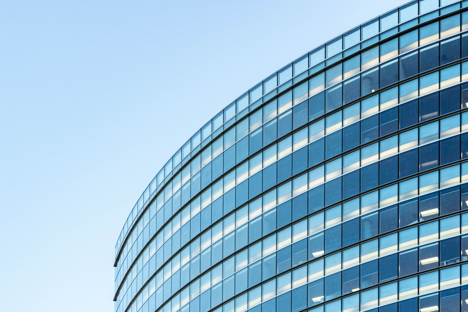 Modern glass office building against a clear sky