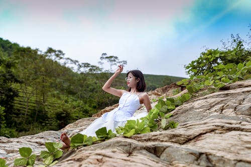 Photo Of Woman Sitting On Top Of Rock