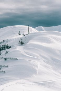 阴天之下，白雪覆盖的山脉和通讯塔构成了一幅令人惊叹的冬日美景
