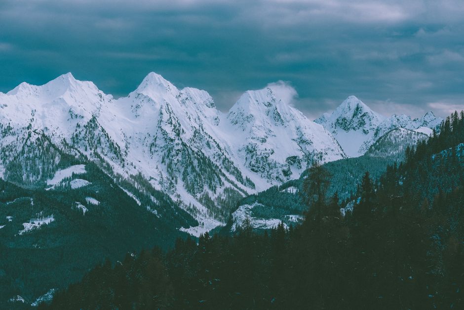 Peaceful snowy mountain range under cloudy sky, perfect nature scenery.