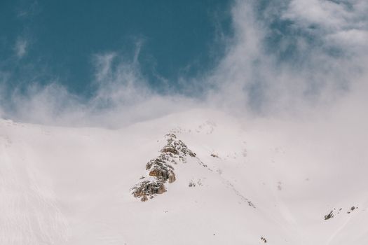 一座白雪皑皑的山峰宁静地笼罩在冬雾中，天空晴朗