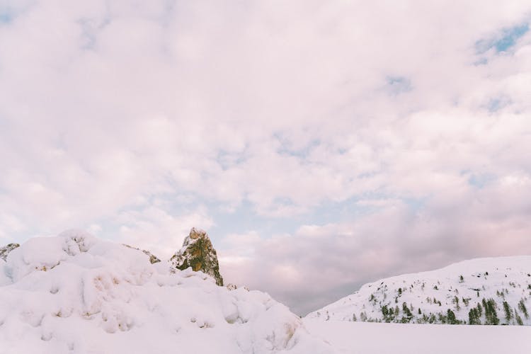 Photo Of Snow Covered Mountains Under Cloudy Sky