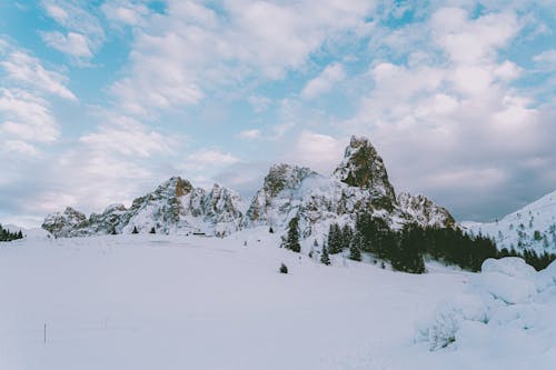 Photo Of Snow Covered Mountains Under Cloudy Sky