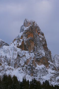 Stunning snow-covered mountain peak with twilight sky, ideal for winter and nature photography.