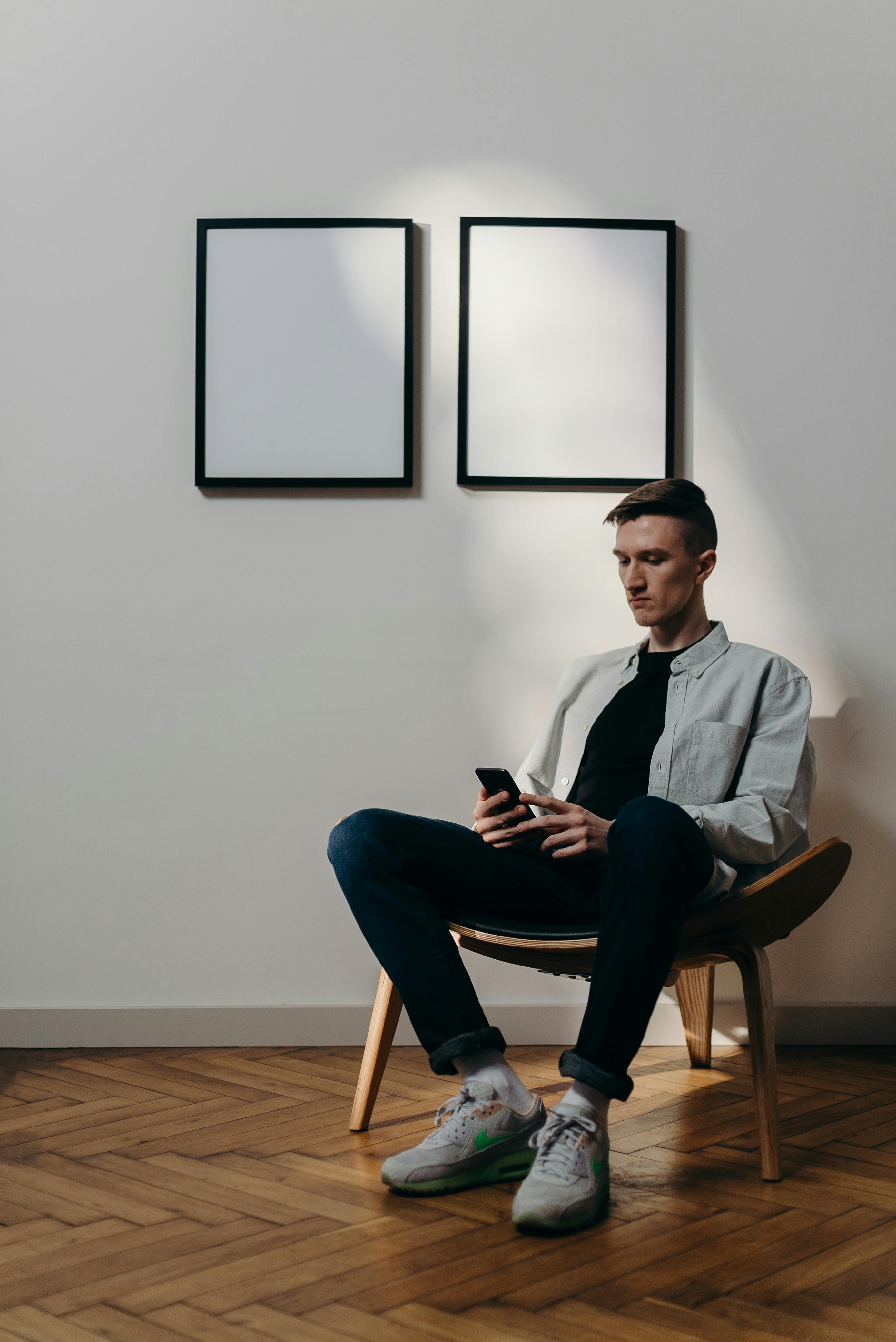 man in blue denim jacket sitting on chair