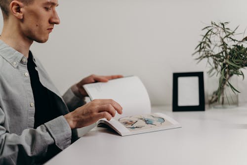 Man in Black Suit Holding White Printer Paper