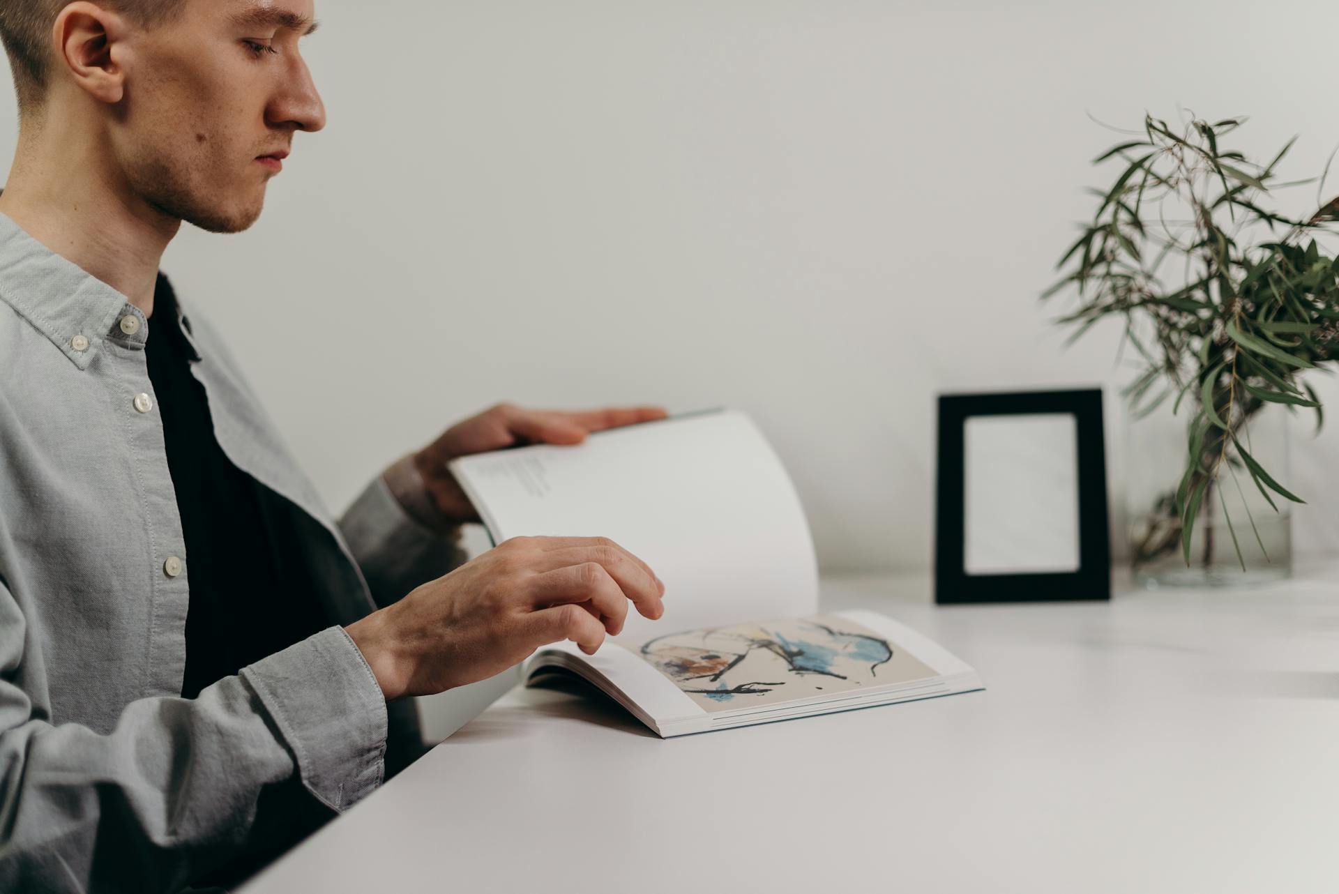 Man in Black Suit Holding White Printer Paper