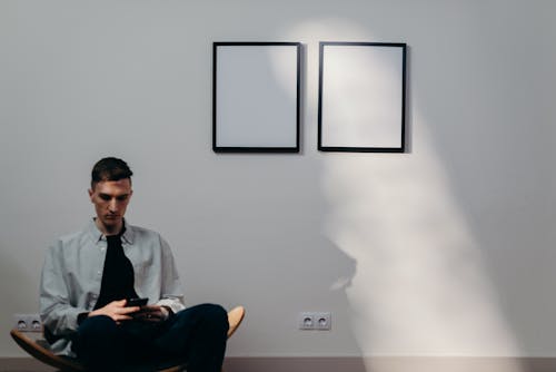 Free Man in Gray Dress Shirt Sitting on Yellow Chair Stock Photo