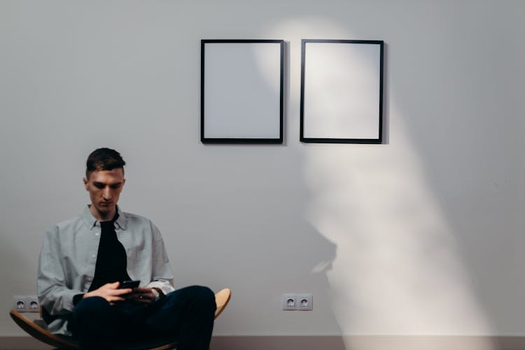 Man In Gray Dress Shirt Sitting On Yellow Chair