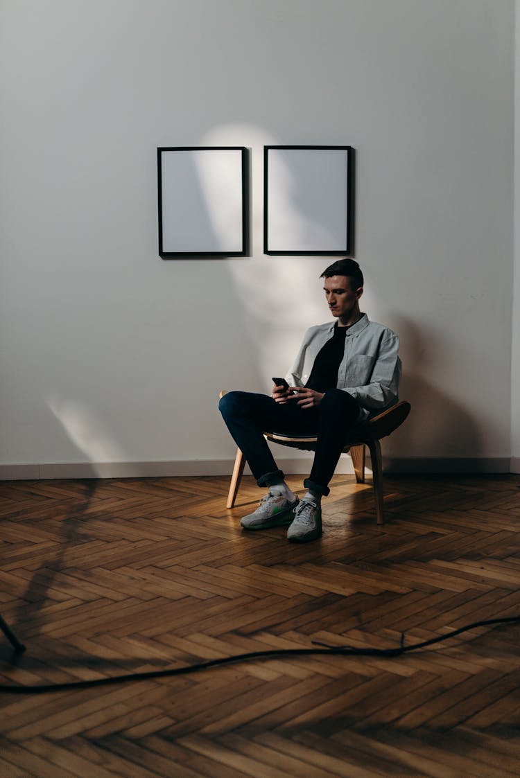 Man In Gray Dress Shirt Sitting On Black Chair