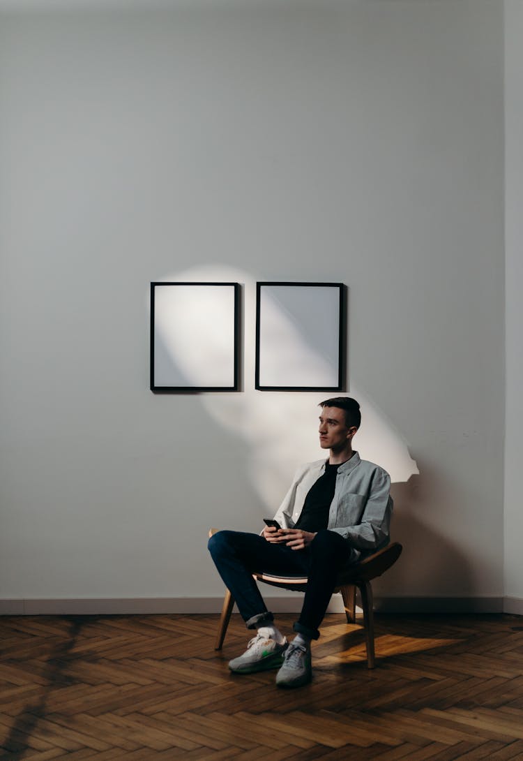 Man In Gray Dress Shirt Sitting On Black Chair