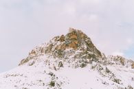晴朗的冬日天空下，矗立着白雪覆盖的雄伟山峰