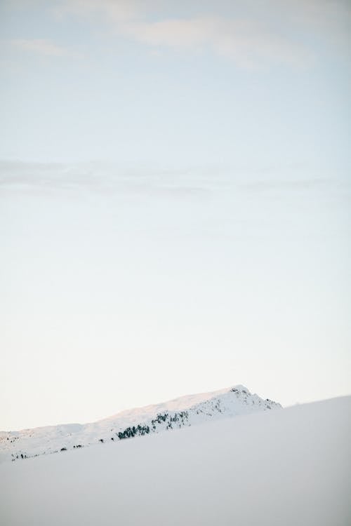 Photo Of Snow Covered Mountain Under White Sky