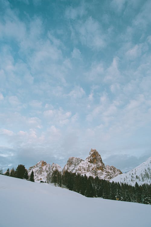 Photo Of Snow Covered Mountains Under Cloudy Sky