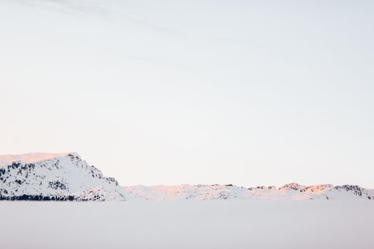 黎明时分，晴朗的天空下，白雪皑皑的山脉景色壮丽