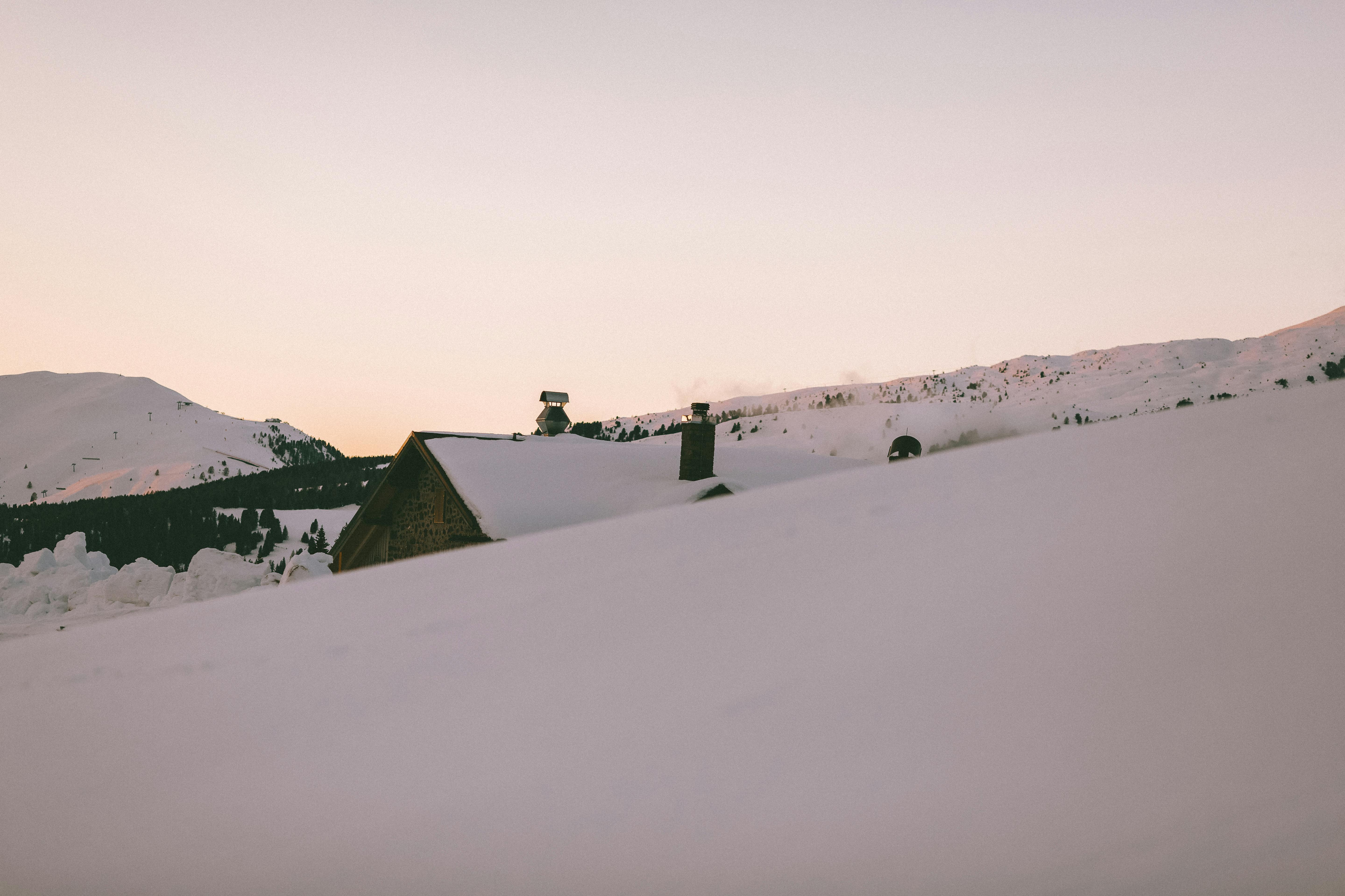 Prescription Goggle Inserts - Tranquil mountain scenery with snow-covered house at sunset in winter.