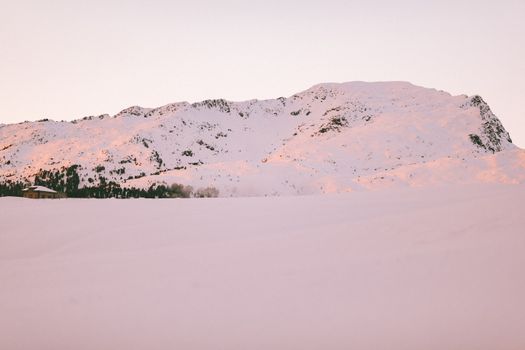 日出时分，白雪皑皑的山地一片宁静，展现了大自然的静谧之美