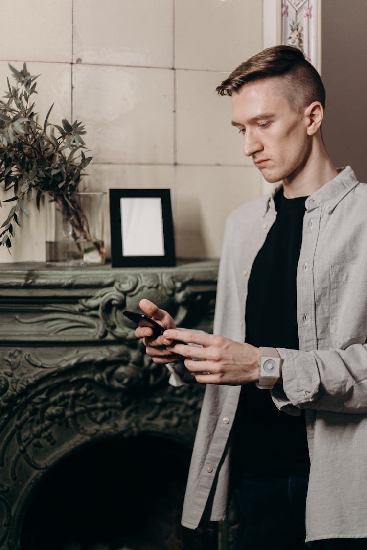 Man In Gray Dress Shirt Holding Black Smartphone