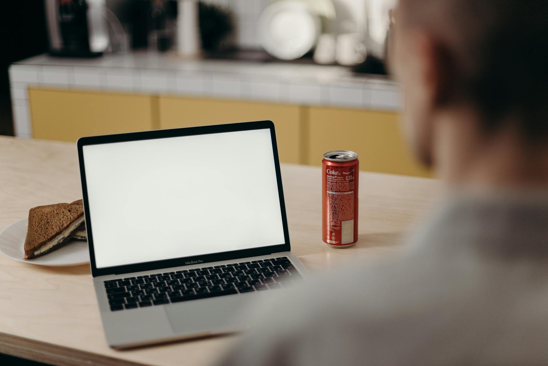 Red Can Beside Macbook Pro on Table