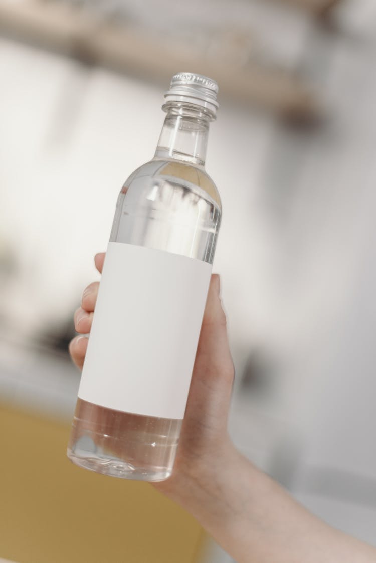 Photo Of Person Holding Clear Glass Bottle