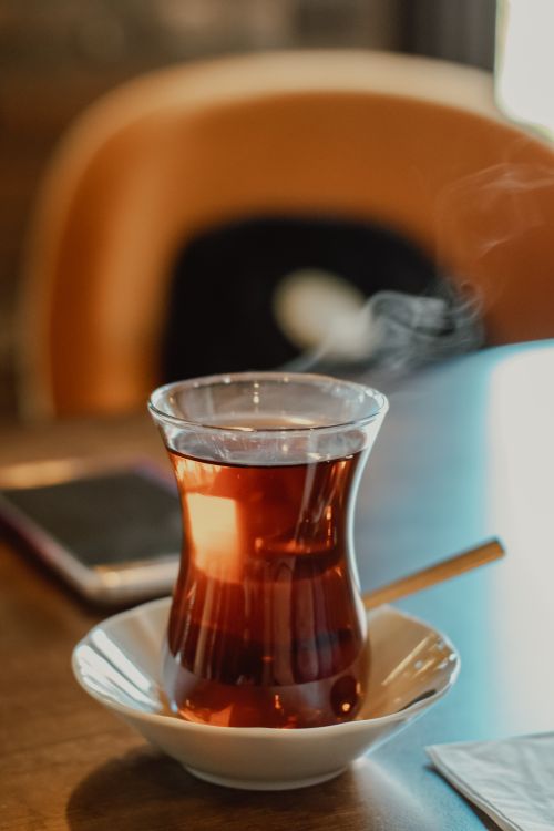 Free A close-up of steaming Turkish tea served in a traditional glass on a saucer, perfect for café scenes. Stock Photo