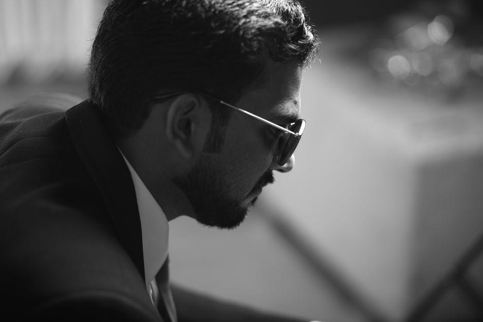 Artistic black and white side profile of a man wearing sunglasses, styled in a modern suit.