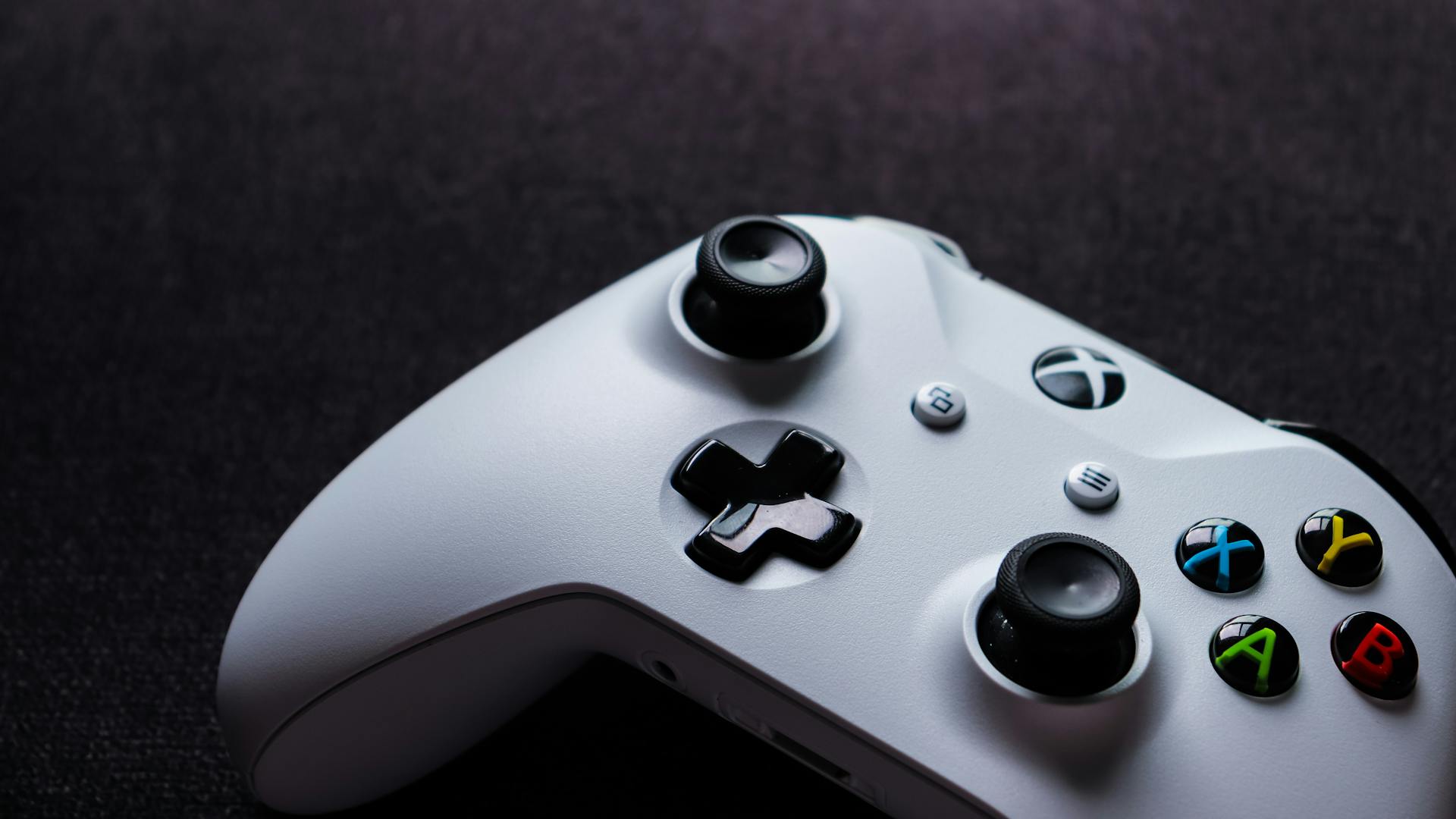 White Xbox controller close-up, highlighting buttons and design, perfect for gaming themes.