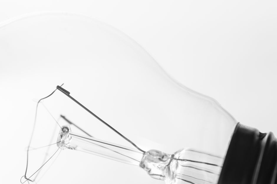 Minimalist black and white image showcasing a close-up of a clear glass light bulb.
