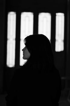 室内，一个女人站立的剪影唤起孤独与内省