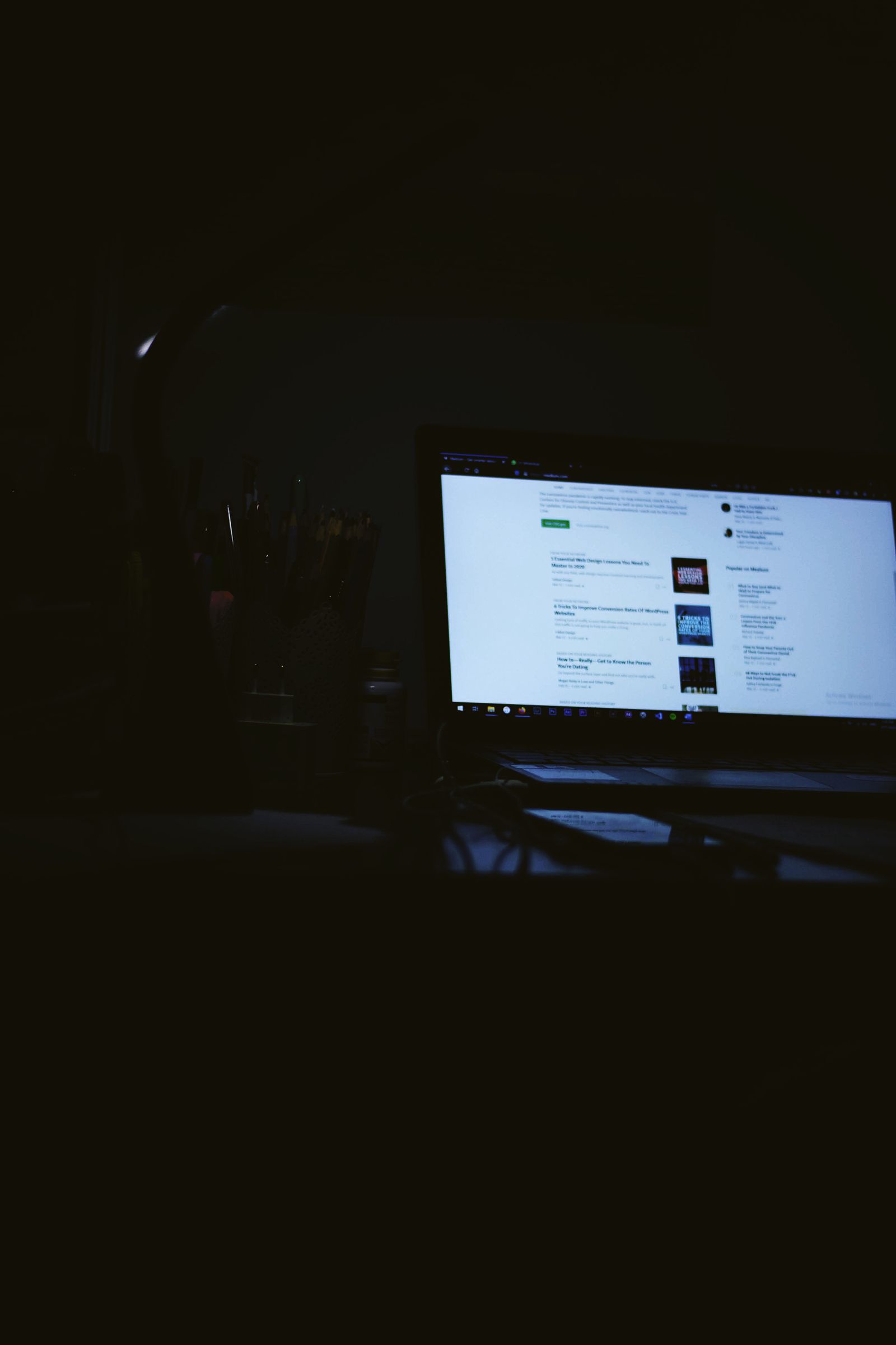 A laptop screen glowing in a dark, quiet editing workspace