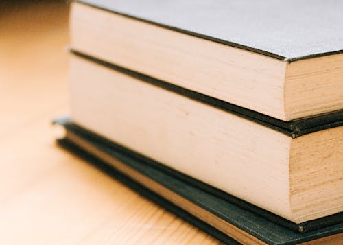 Hardbound Books on Brown Wooden Table