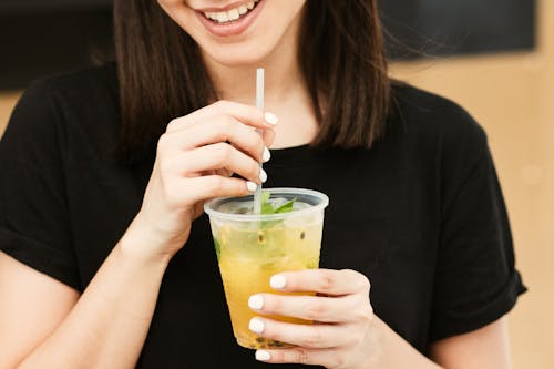 Woman in Black Shirt Holding Clear Plastic Cup With Straw