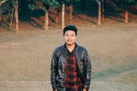 一名穿着黑色皮夹克、面带微笑的男子的户外休闲肖像