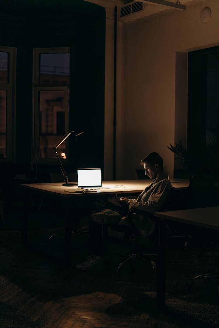 Man In Black And White Stripe Dress Shirt Sitting On Chair In Front Of Macbook