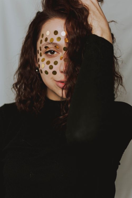 Free Creative portrait of a woman with gold dots on her face, showcasing unique artistic expression. Stock Photo
