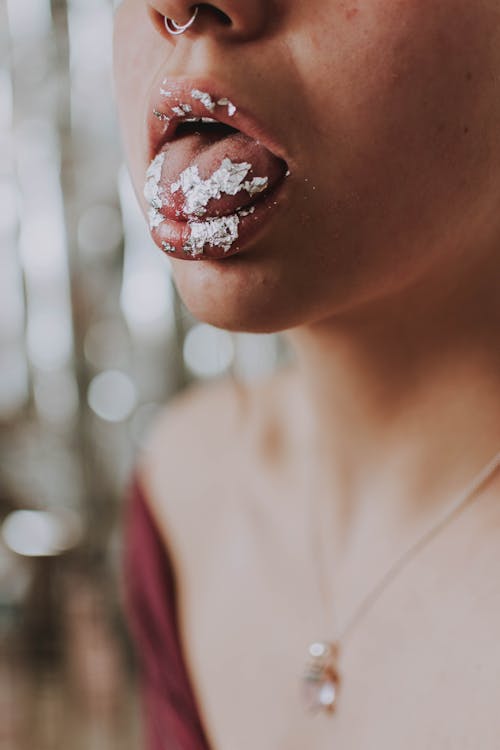 Free Anonymous young woman showing tongue with cream Stock Photo