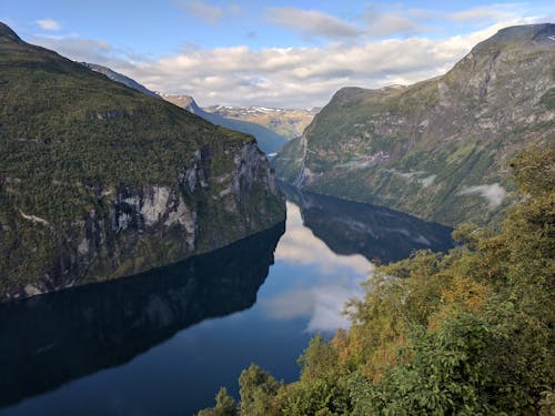 Green and Brown Mountains Beside River Under White Clouds and Blue Sky