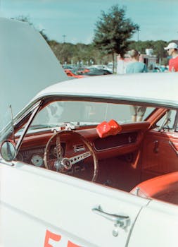 Classic red and white vintage car interior with hanging dice on display in Orlando. Vibrant and nostalgic style.