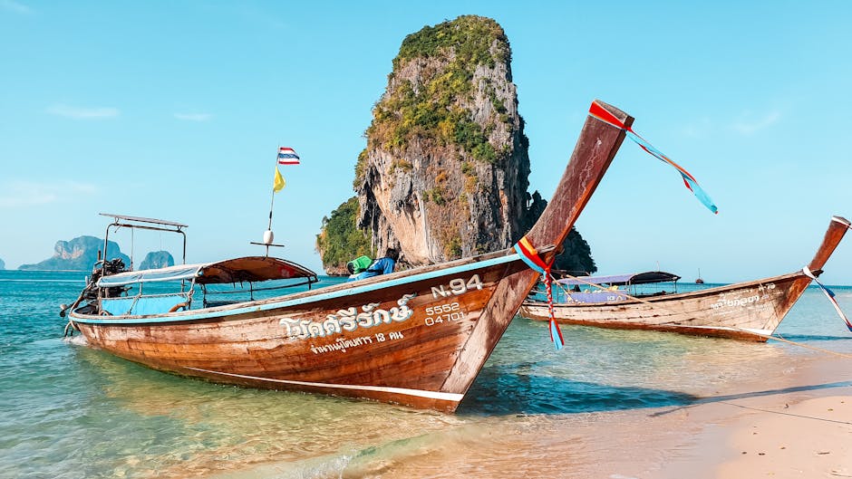 long-tail boats on a beach in Thailand - solo backpacking destinations long-tail boats on a beach in Thailand - solo backpacking destinations
