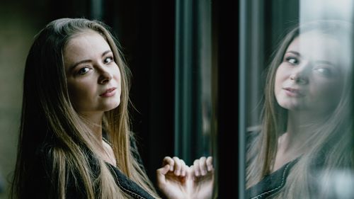 Free A contemplative woman looking out a window in Chicago, reflecting on her thoughts. Stock Photo
