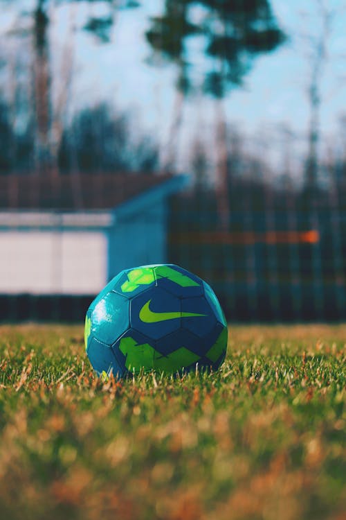 Blue and Green Soccer Ball on Green Grass Field