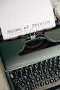 Green and White Typewriter With White Printer Paper