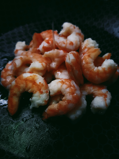 Free Close-up of delicious cooked prawns on a black surface, highlighting their rich texture. Stock Photo